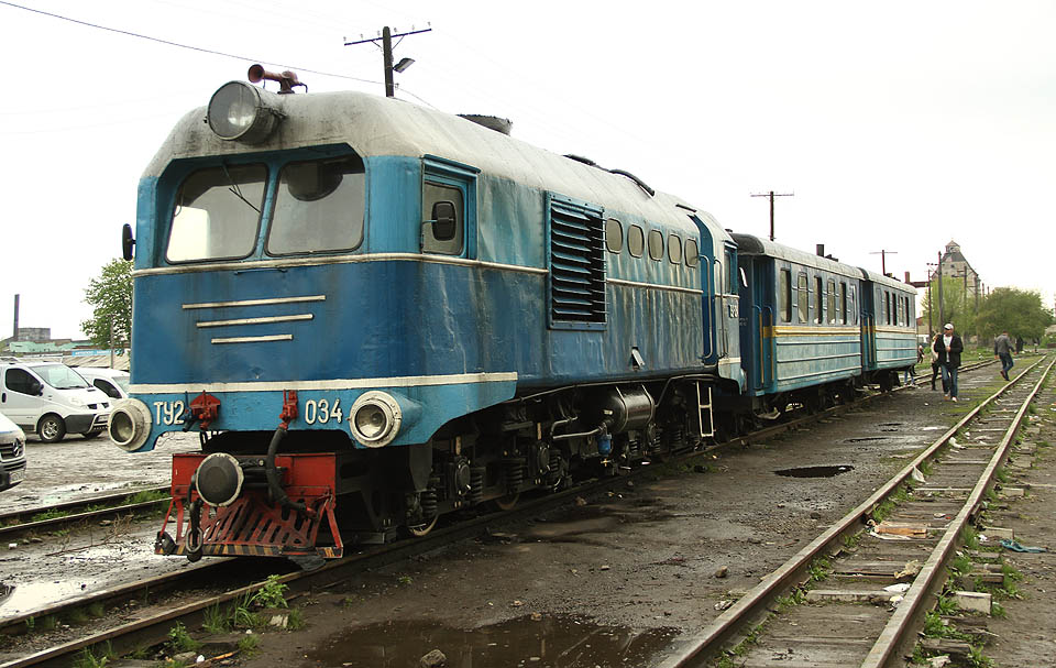 Úzkokolejný vláček o dvou vagónech tažený lokomotivou TU2-034, která kdysi jezdila v dalekém Kazachstánu čeká na svoji dávku másla.