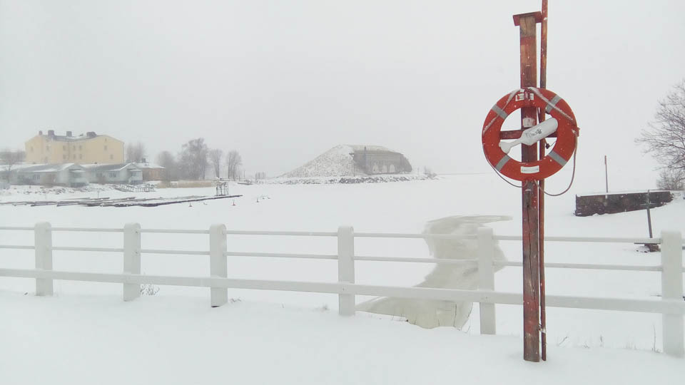 Na jednom z mostů spojujících ostrovy Suomenlinny se skví zasněžené záchranné kolo, kdyby se někdo při pádu probořil skrz zamrzlou mořskou hladinu.