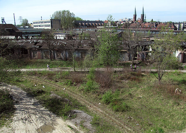 Typická postindustriální krajina Horního Slezska. Úzkokolejka se proplétá mezi továrnami bezprostředně nalepenými na obytnou zónu. Foceno ze silničního mostu přes hlavní trať.