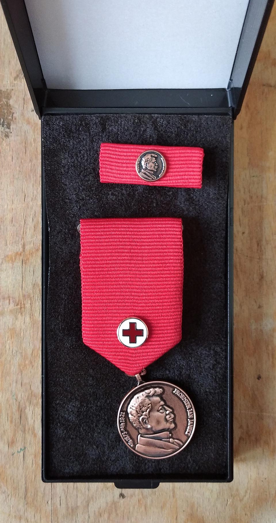 Bronzová medaile Prof. MUDr. Jana Janského má průměr 27 mm a je na červené stuze o rozměrech 4 cm × 3 cm s miniaturou ve tvaru červeného kříže v bílém poli.
