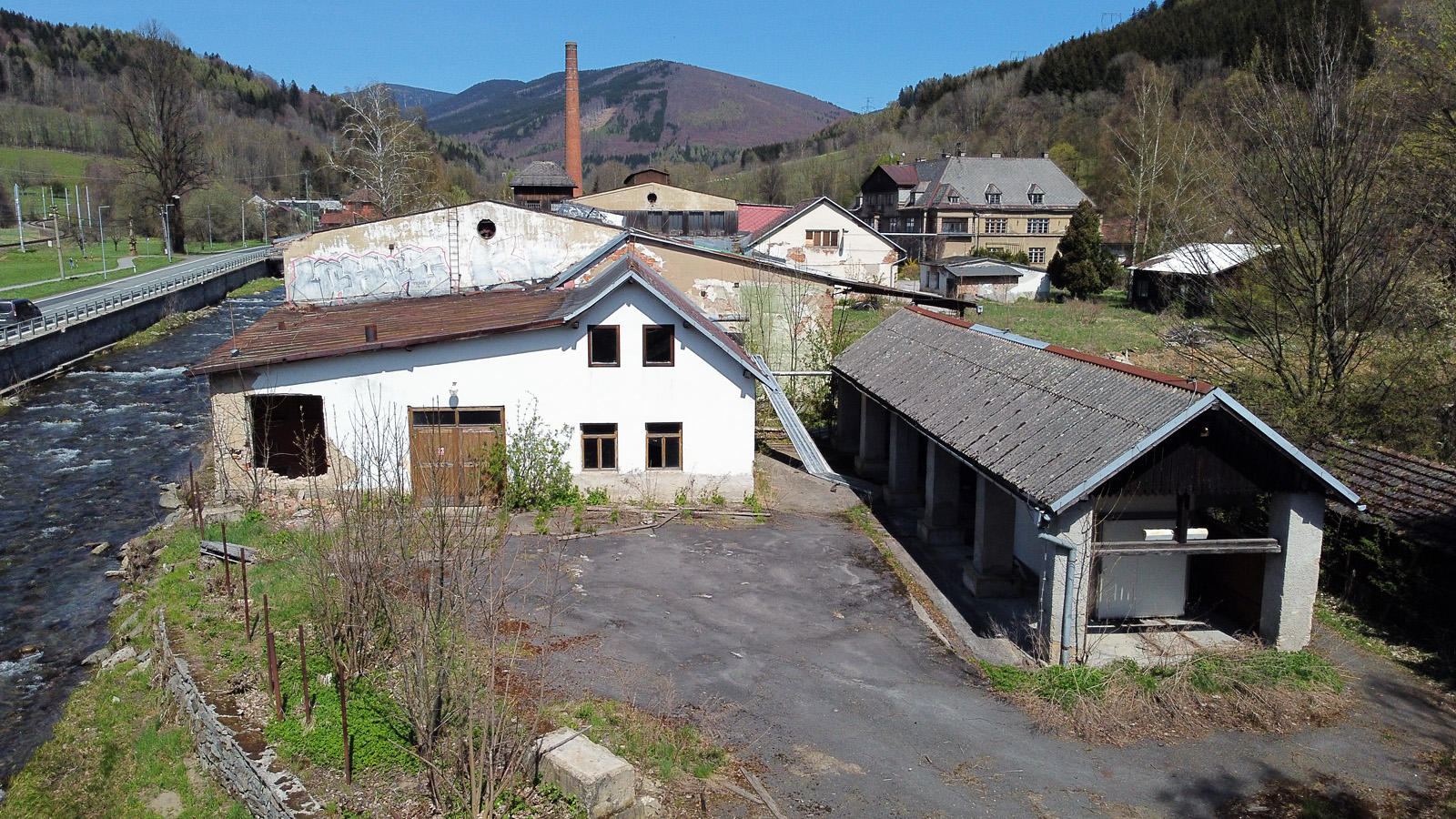 Celkový pohled na továrnu, vlevo za řekou je vidět <a href="/Tema/Loučná nad Desnou-Rejhotice (nákl a žzast)">nádraží Loučná nad Desnou-Rejhotice</a>.