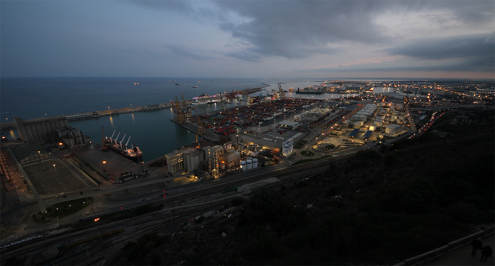 Usínající přístavní čtvrť protkaná kolejemi tří rozchodů.