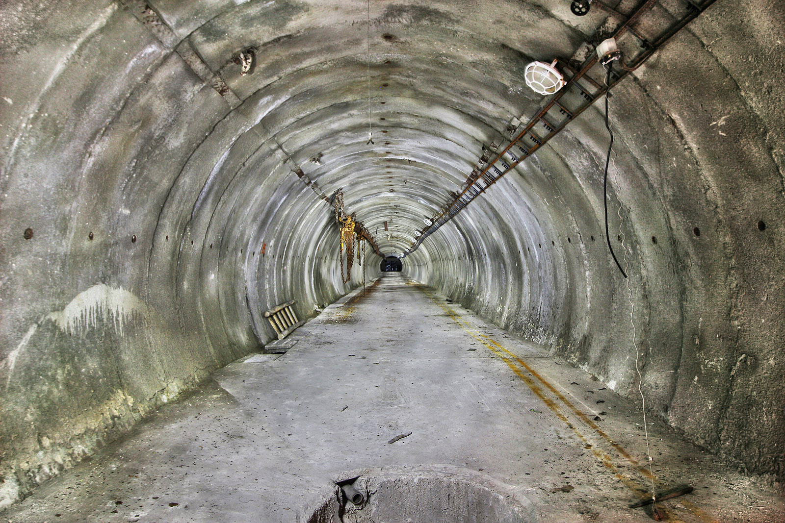 Tunel je rovný, suchý a čistý. Při pohledu od čelby zpět je vidět polovinu kruhové jímky, do které ústí z nějasných důvodů kovová trubka. Mohlo by jít o zařízení provizorní betonárky?