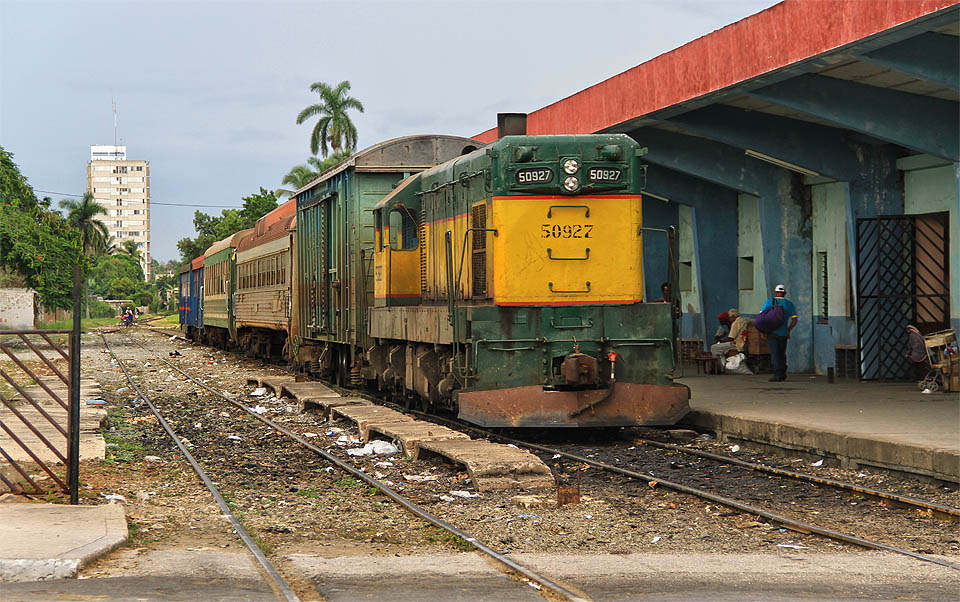 Původem americká lokomotiva Genaral Motors EMD G8 (dodávaná od roku 1954) evidenčního čísla 50927 s vlakem složeným z japonských, italských, amerických a ruských vozů u severního nástupiště stanice Camagüey.