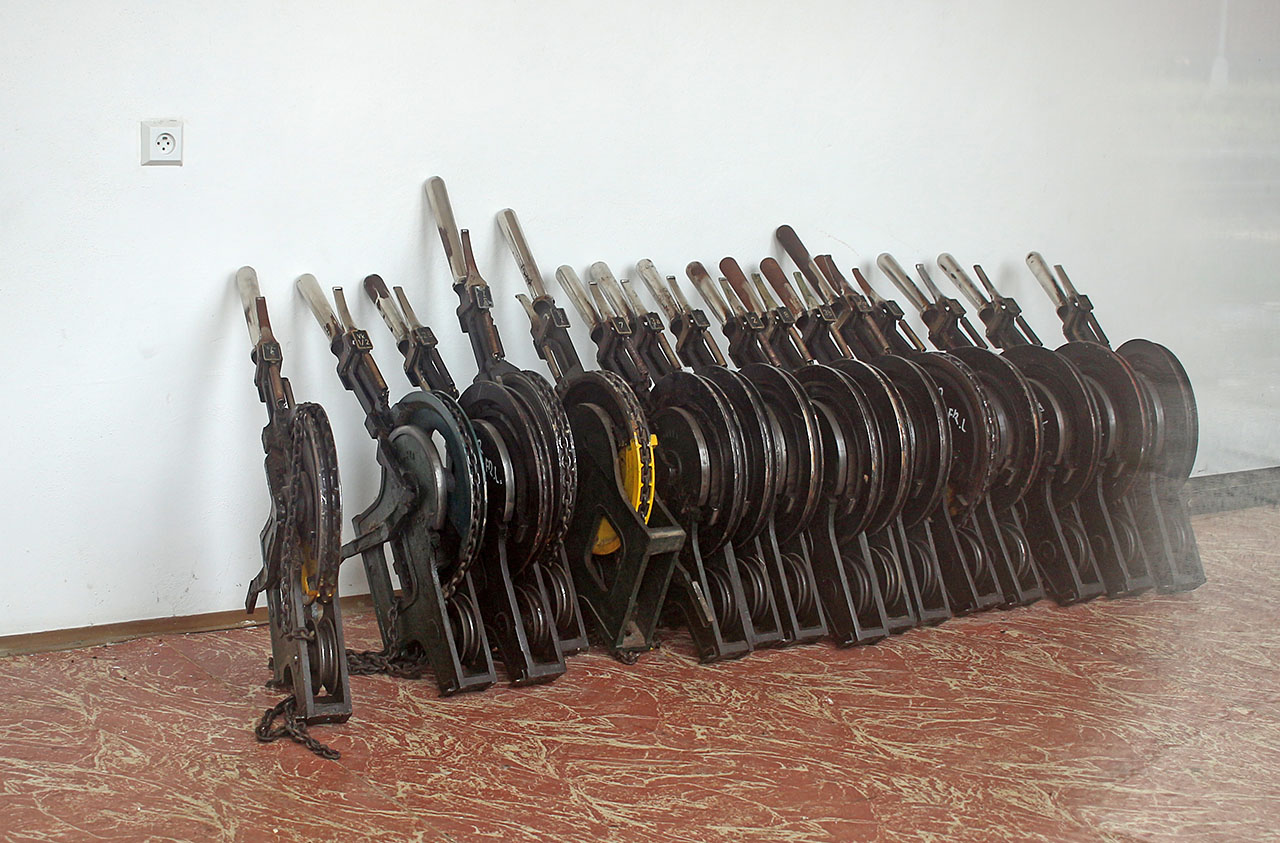 Přes okno lze nahlédnout do místnosti, kde Správa železnic zřejmě skladuje páky na stavění výhybek a návěstidel z elektromechanických zabezpečovacích zařízení.