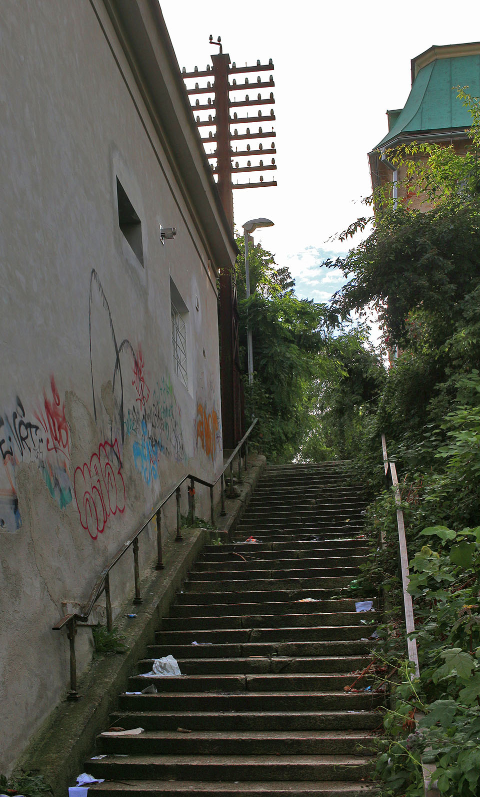 Sloup je dominantou nároží zejména při výstupu po schodech z ulice Na Svahu. Vpravo je pak vidět Franzův dům.