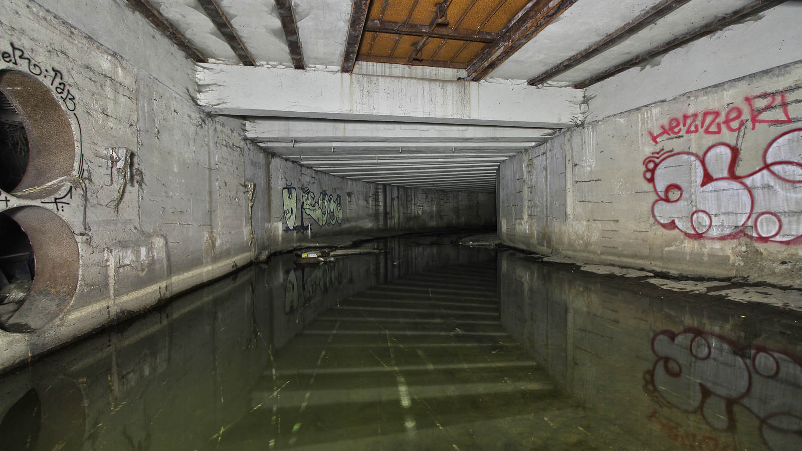 Pohled na nejvyšší část tunelu Botiče, zpod železniční trati. Vlevo je vidět ocelové průchodky spojující tunel se systémem dešťové kanalizace.