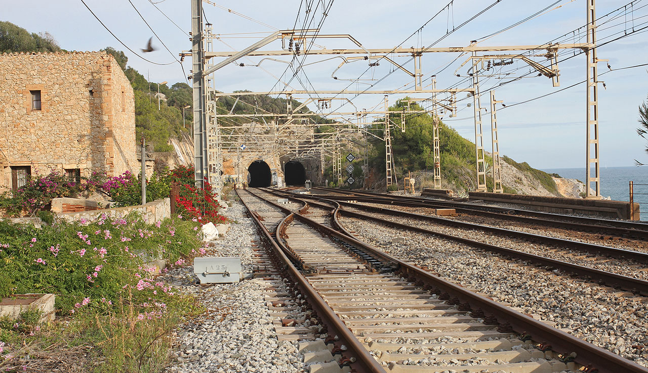 Zhruba v těchto místech odbočovala vlečka ze 3. staniční koleje, která je na snímku umístěna zcela vlevo. V pozadí dva tunely obligátního názvu Garraf.
